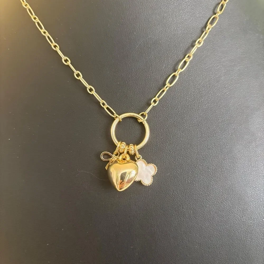 Gold Tone Multi-Charm Necklace w/ Puffy Heart, White Clocer & Gold Bow.